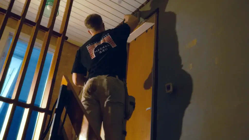 Håndværker installerer træpaneler i hjemmet, professionelle løsninger til renovering og komfort.